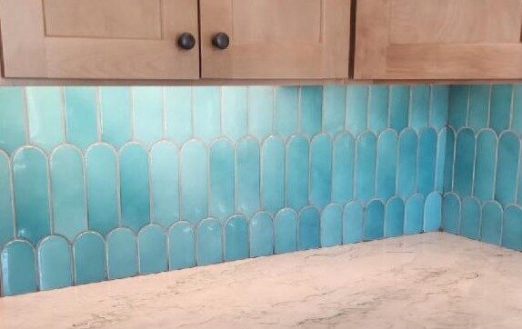 Custom kitchen remodel by Green Men Restoration featuring turquoise tile backsplash, quartz countertops, and custom wood cabinetry.